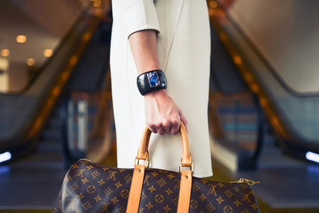 Luxury consumer with handbag in modern shopping environment, digital product passport consumer trust in action.