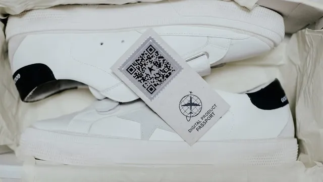 A pair of white sneakers in a box with a QR Code for Digital Product Passport