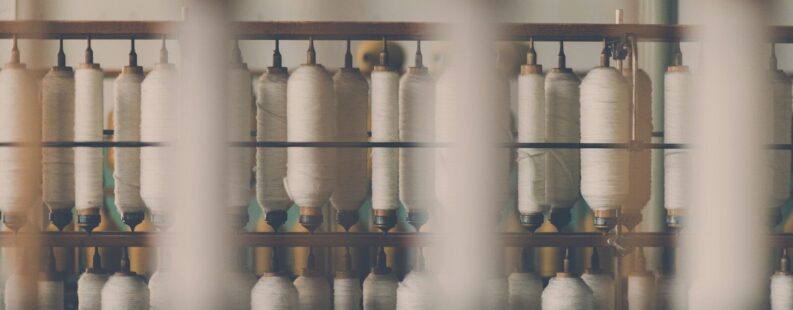 White textile on wooden rack — LCA digital product passport environmental data for fashion