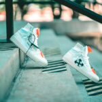 a pair of white sneakers sitting on top of a cement step