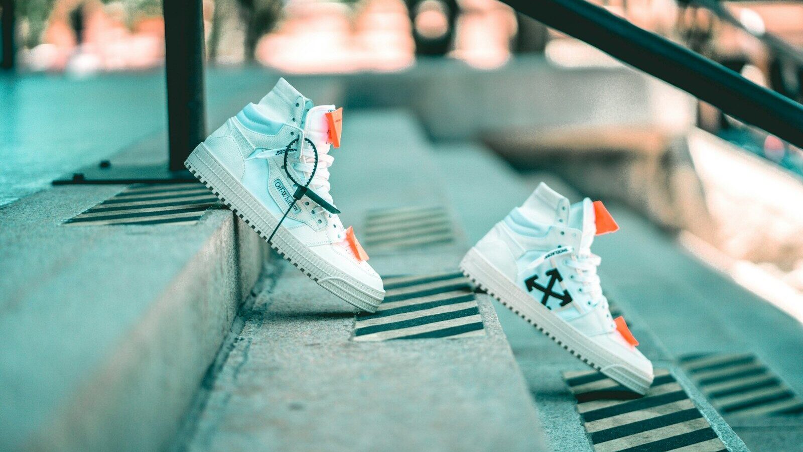 a pair of white sneakers sitting on top of a cement step