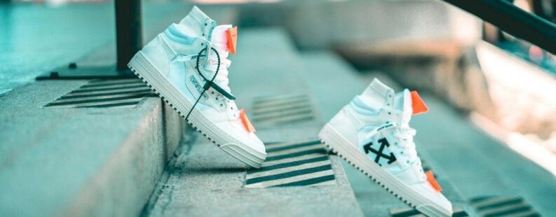 a pair of white sneakers sitting on top of a cement step