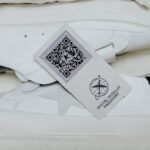 A pair of white sneakers in a box with a QR Code for Digital Product Passport
