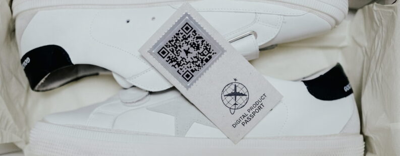 A pair of white sneakers in a box with a QR Code for Digital Product Passport